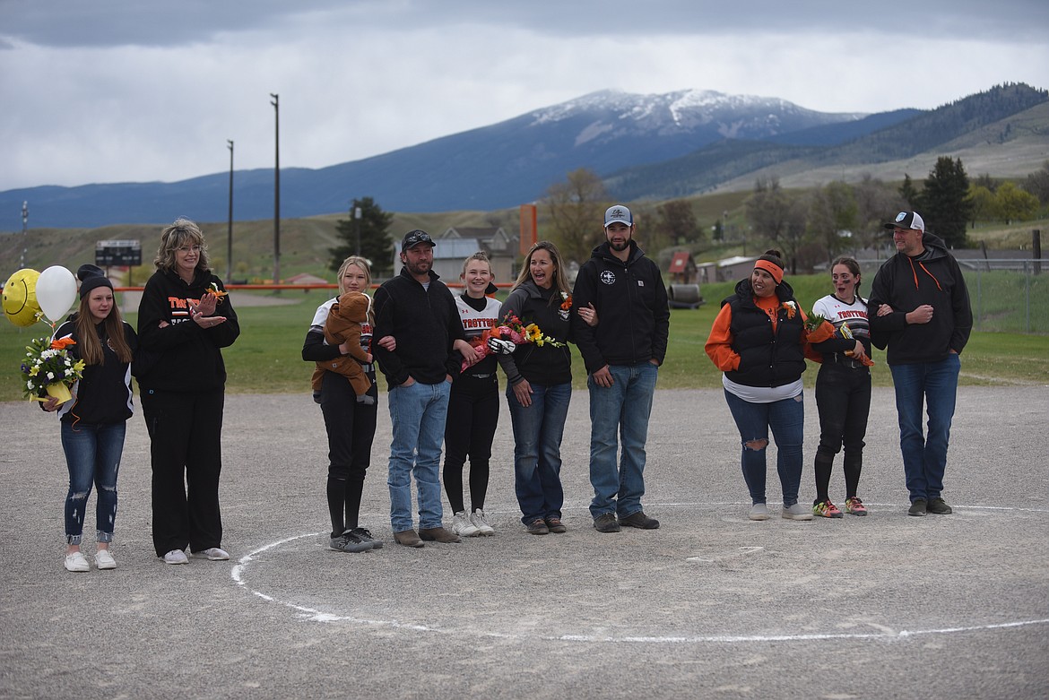 Plains-Hot Springs softball players Skylar Bergstrom, Kenzi Blood and team manager Dacia Black-Garrison and their families celebrated Senior Night last Saturday between games of a doubleheader against Troy. The Trotters swept both games to improve to 8-6. (Scott Shindledecker/Valley Press)