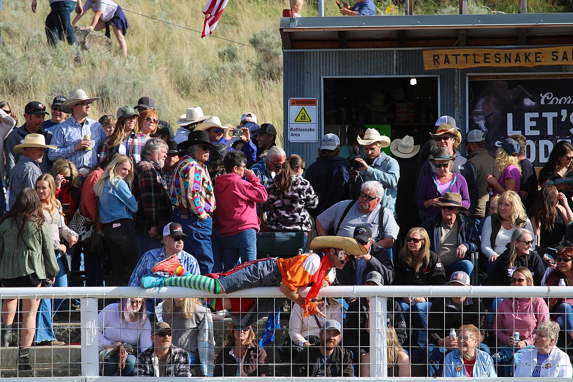 Whistle-Nut the clown straddles the fence at the 64th Colorama Rodeo in Grand Coulee Saturday.