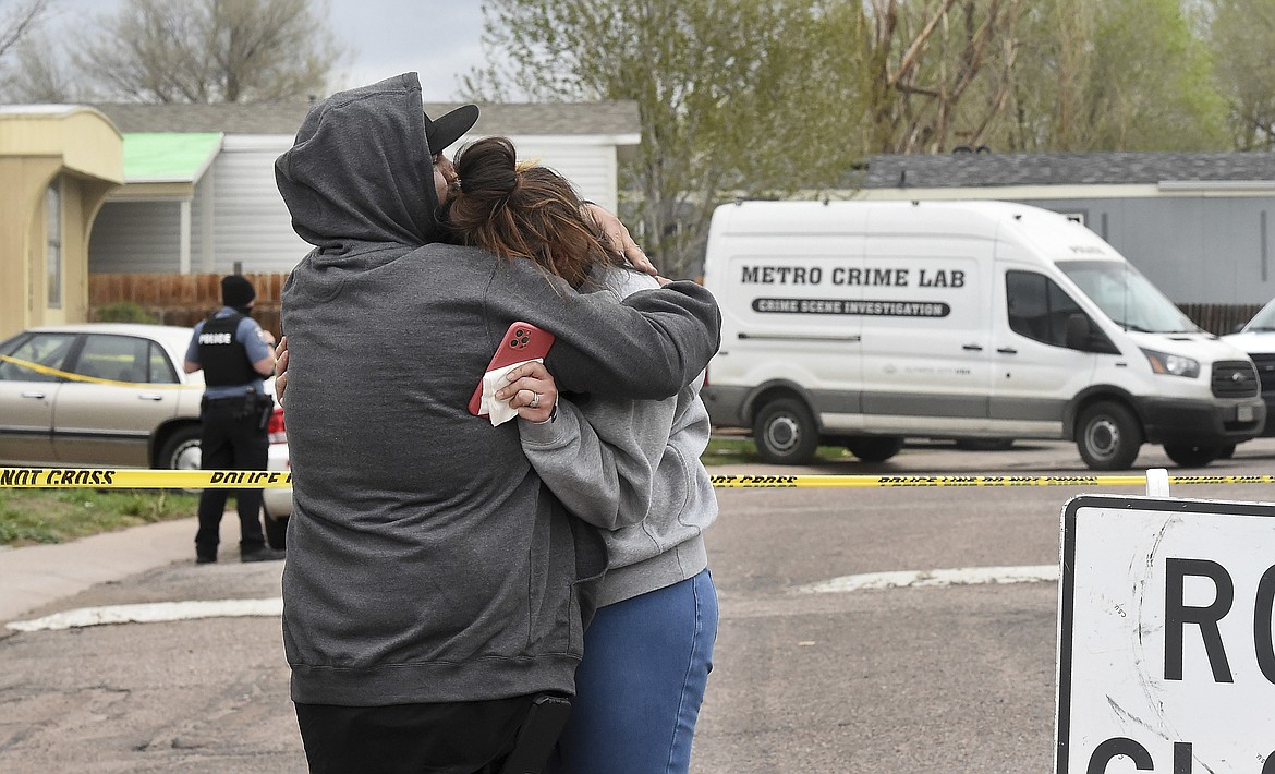 Freddy Marquez kisses the head of his wife, Nubia Marquez, near the scene where her mother and other family members were killed in a mass shooting early Sunday, May 9, 2021, in Colorado Springs, Colo. The suspected shooter was the boyfriend of a female victim at the party attended by friends, family and children. He walked inside and opened fire before shooting himself, police said. Children at the attack weren’t hurt and were placed with relatives.