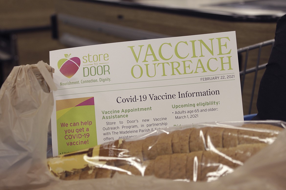 In this Feb. 25, 2021, file photo a sheet with information about how to get a COVID-19 vaccine sticks out of an order of groceries for delivery to a homebound senior citizen in Portland, Ore., through the nonprofit group Store to Door. Oregon Gov. Kate Brown has announced statewide and county COVID-19 vaccination targets, with the hope of reopening the state's economy. The governor said Tuesday, May 11, most statewide coronavirus related restrictions will be lifted when 70% of Oregon's residents who are 16 years and older receive the first COVID-19 vaccine dose.