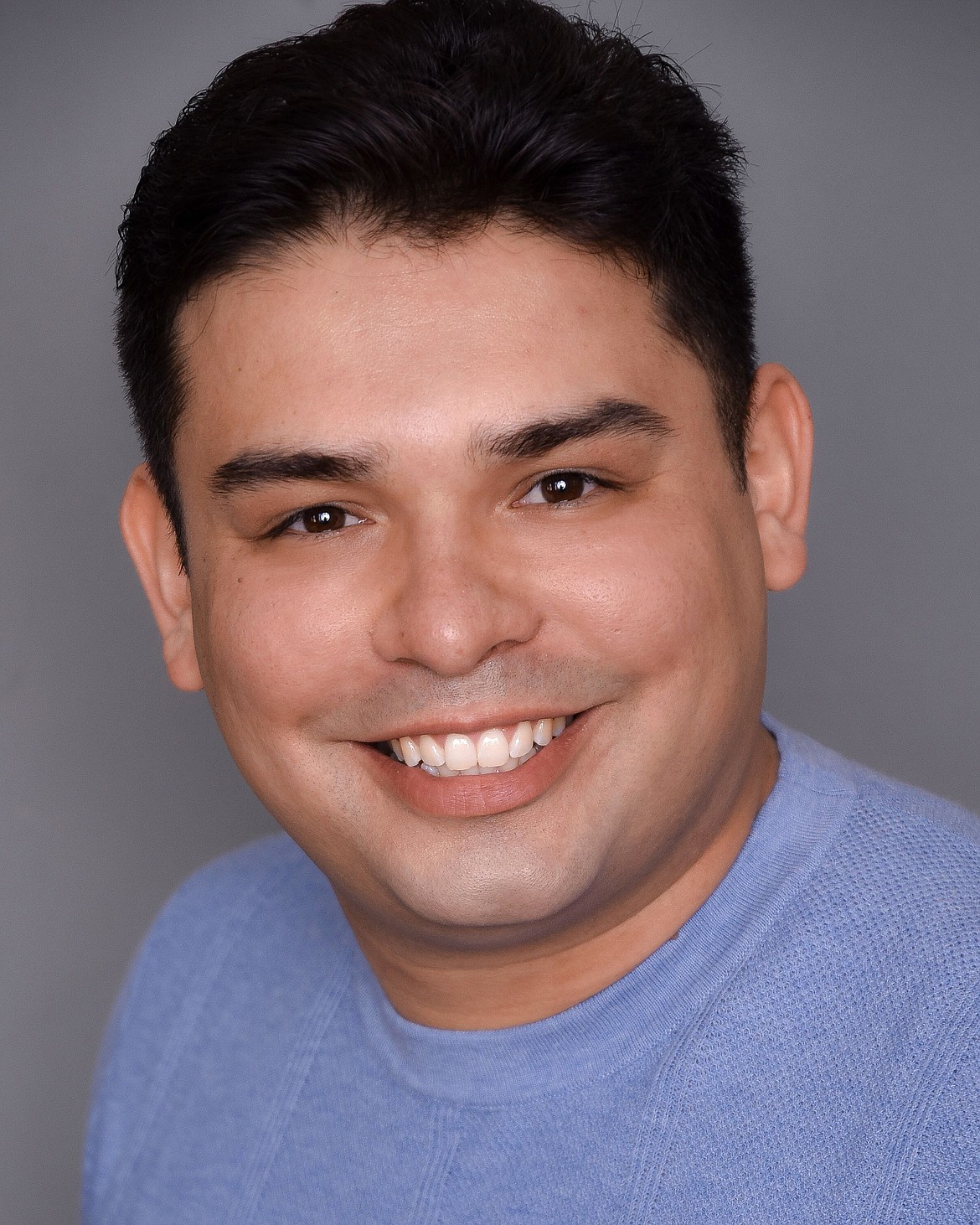 A headshot of Dino Gonzales taken for his talent agency, Seattle Talent.