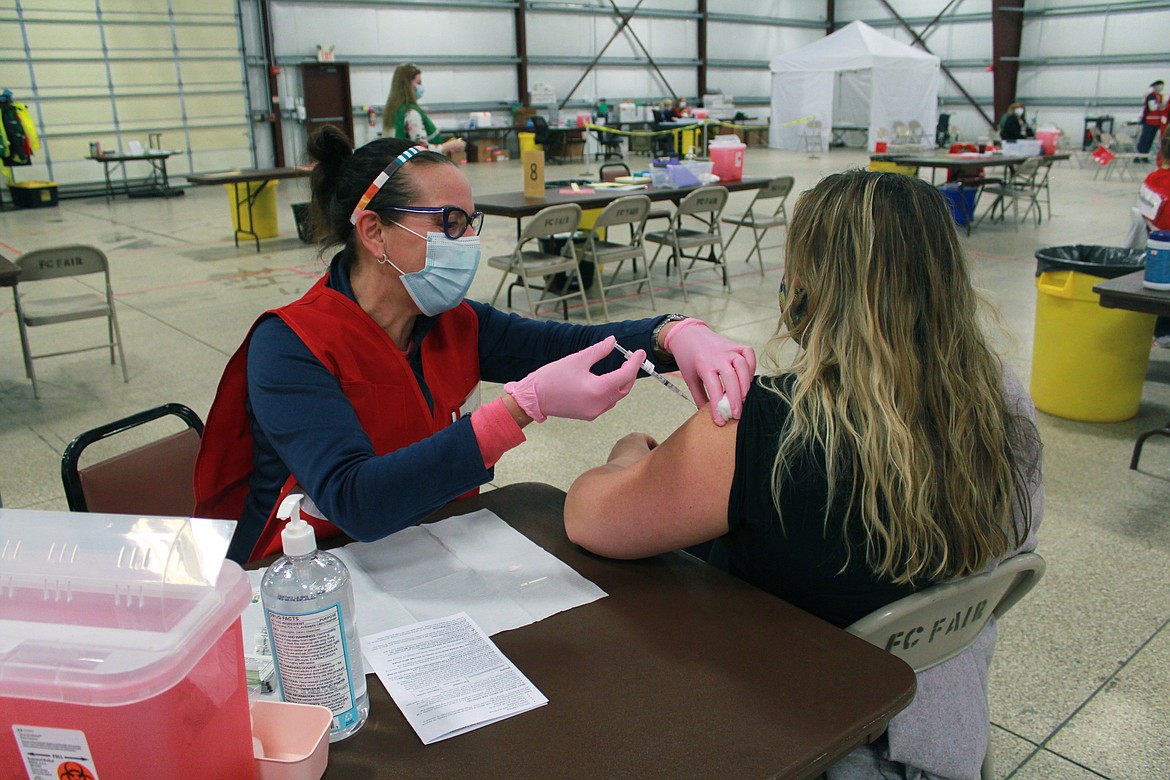 Dawn Stratton, a registered nurse in Kalispell, administers covid-19 vaccines at the Flathead County fairgrounds. While Flathead County is seeing demand for vaccinations lag,
the mass clinic at the fairgrounds has overall been a place of hope. (Katheryn Houghton/KHN)