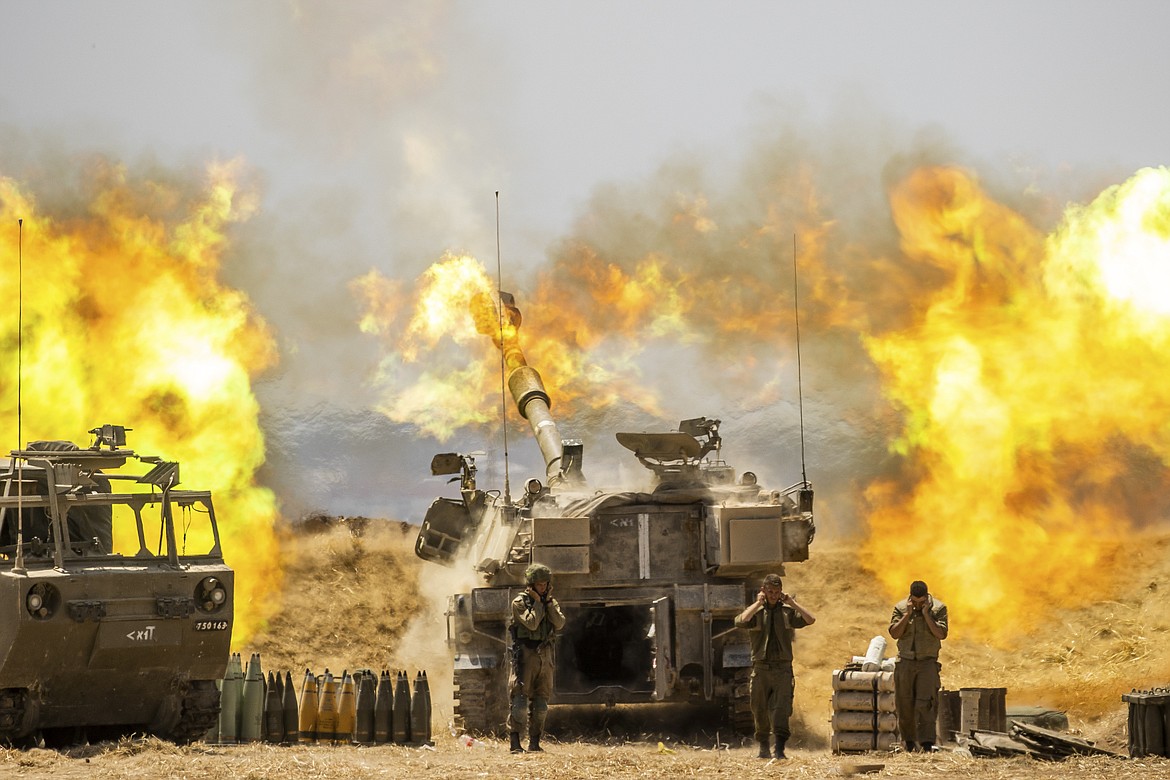 An Israeli artillery unit fires toward targets in Gaza Strip, at the Israeli Gaza border, Wednesday, May 12, 2021.