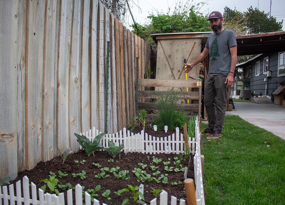 Josh Mohs stands near the new raised garden bed he and his wife put in during the past year with their compost bin at the end of the garden at their home in Moses Lake.