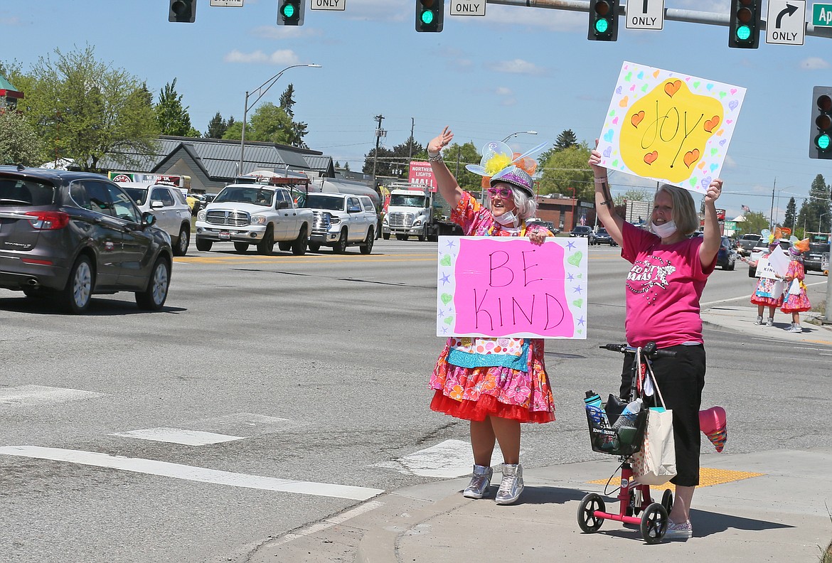 Even with a broken foot, Red Hot Mama Julie Hartley, right, can't say no to spreading merriment as she and Mama colleague Shelli Findley wave at drivers on Highway 95 on Friday afternoon.
