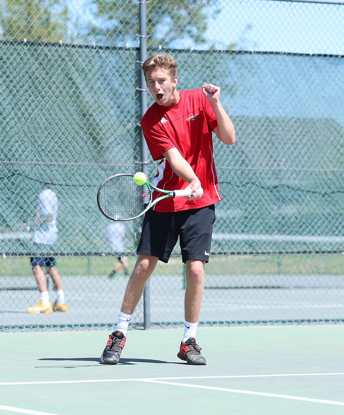 Christian Story returns a serve during the boys doubles regional championship match on Saturday at Travers Park.