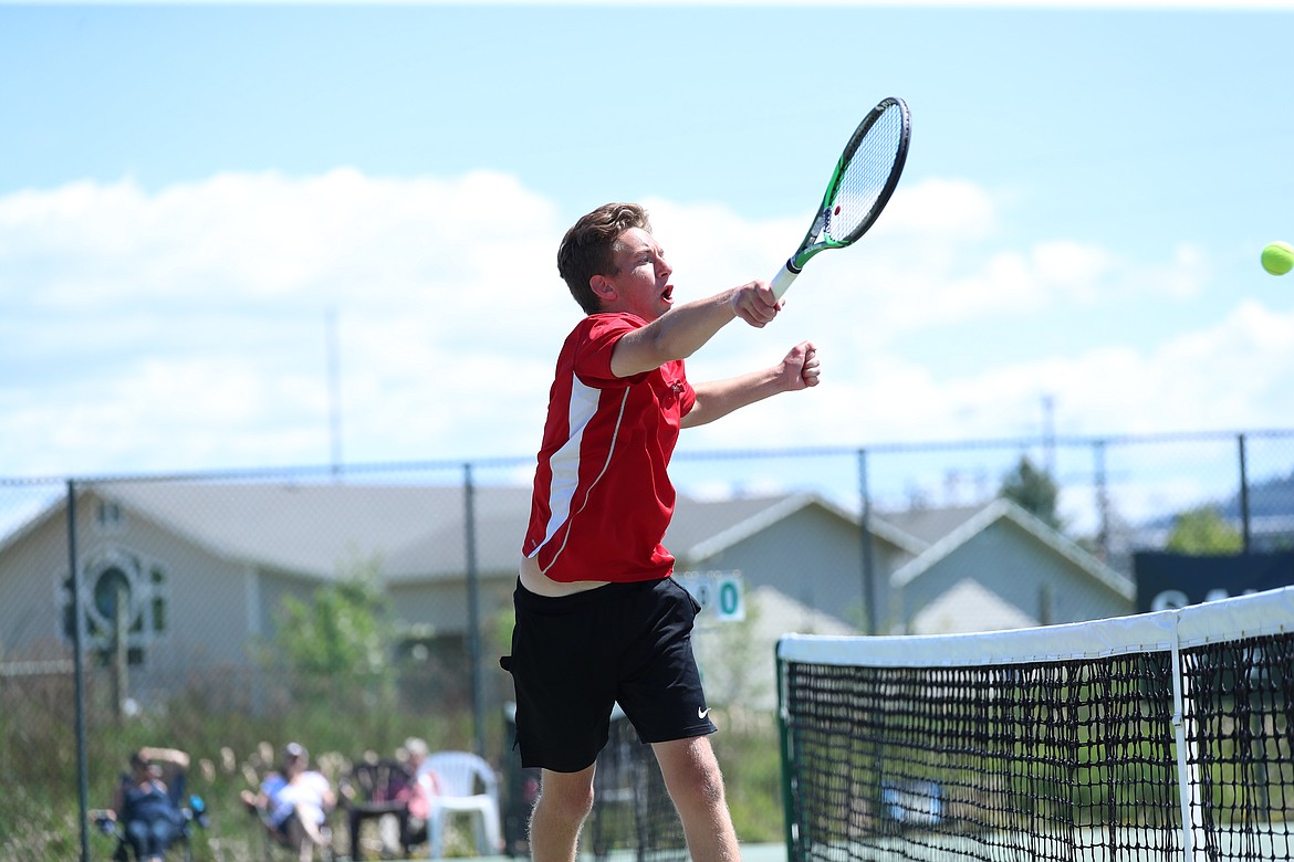 Christian Story hits a volley at the net during the boys doubles regional championship match on Saturday at Travers Park.