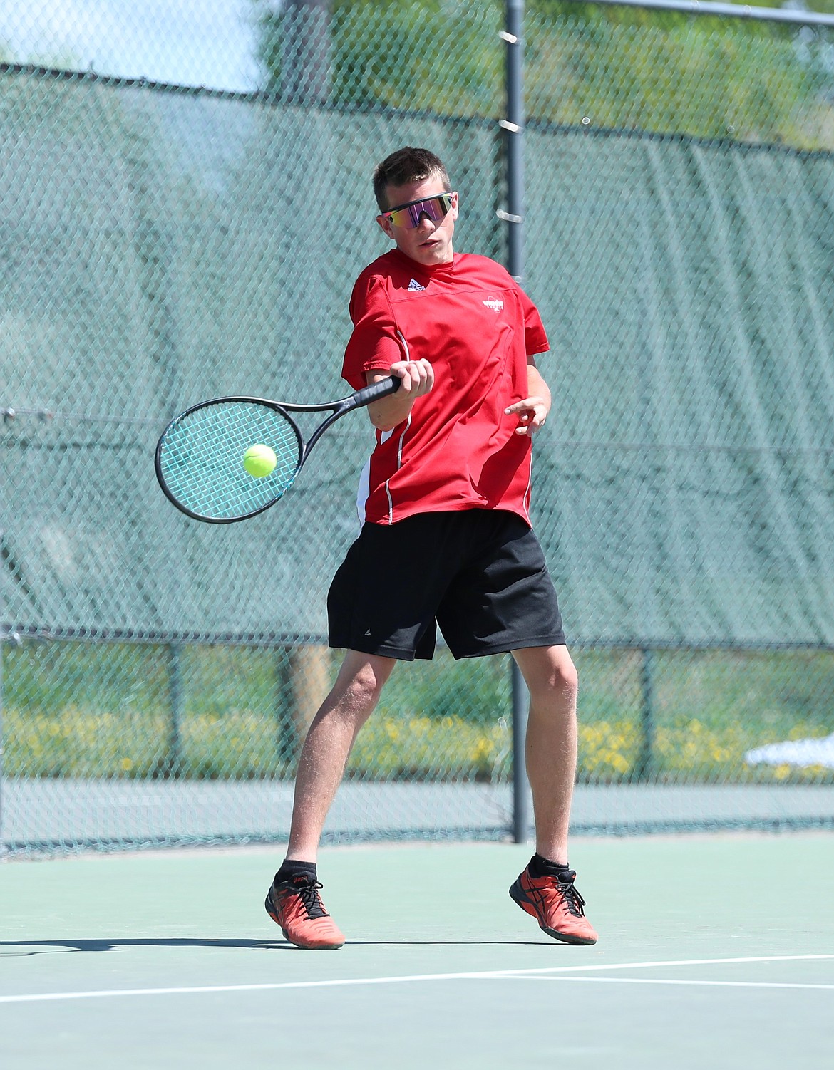 Tyler Korn hits a return during the boys doubles regional championship match on Saturday at Travers Park.
