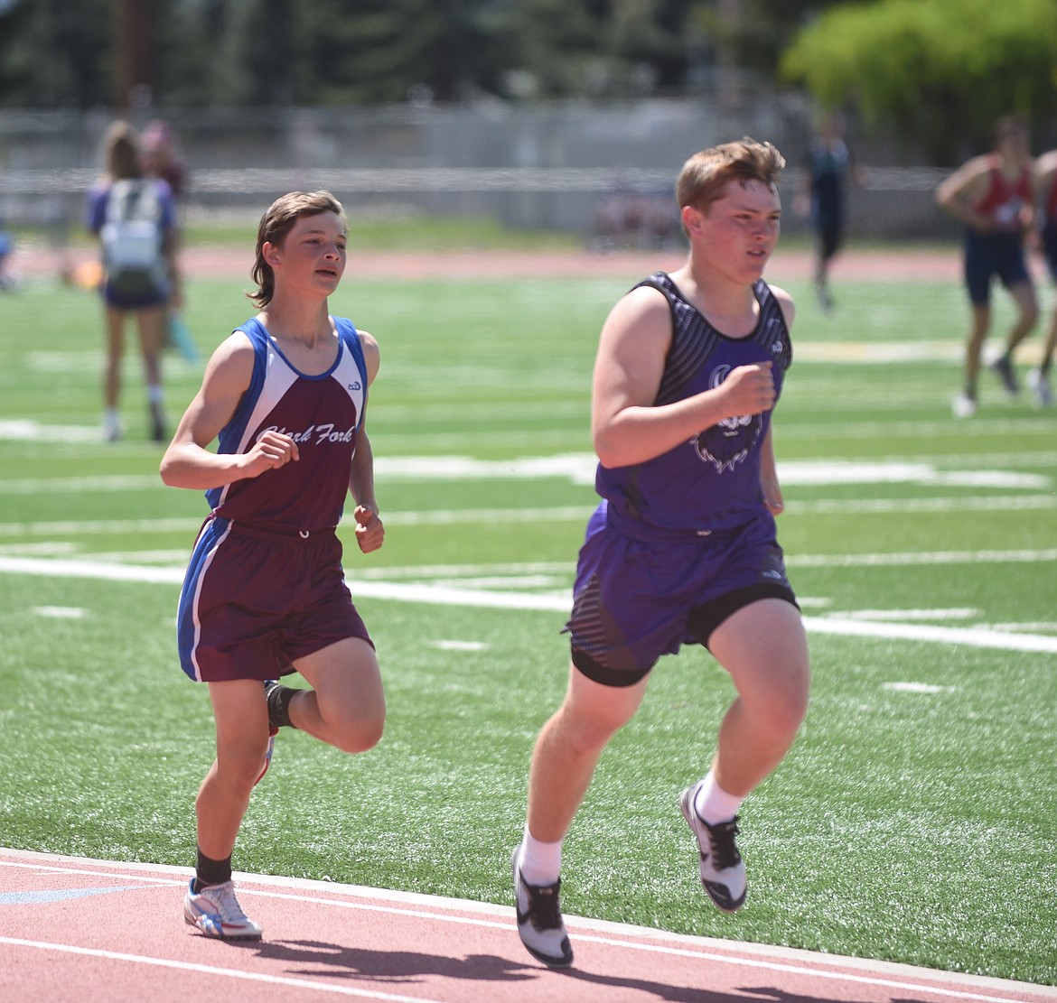 Clark Fork's Allen Ryan runs with Charlo's Tucker Love during the 1,600-meter run Friday at the 14-C District championship at the Missoula County Public School stadium. Ryan edged Love for the district title with a good lunge at the finish line. (Scott Shindledecker/Mineral Independent)