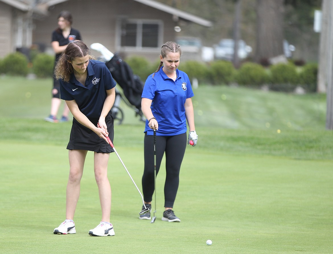 MARK NELKE/Press
Holly Hudson, right, of Coeur d'Alene watches as JoJo Dodge of Lake City putts on the 18th hole last week at the 5A Region 1 golf tournament at Avondale Golf Club in Hayden Lake.