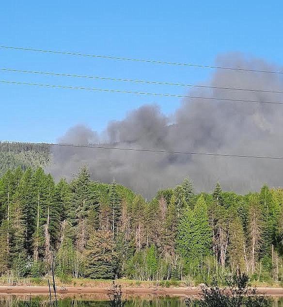 Smoke pours from a fire at a home in Noxon Monday. A Noxon firefighter was burned in the blaze and taken for treatment. (Photo courtesy Mary Verzier)