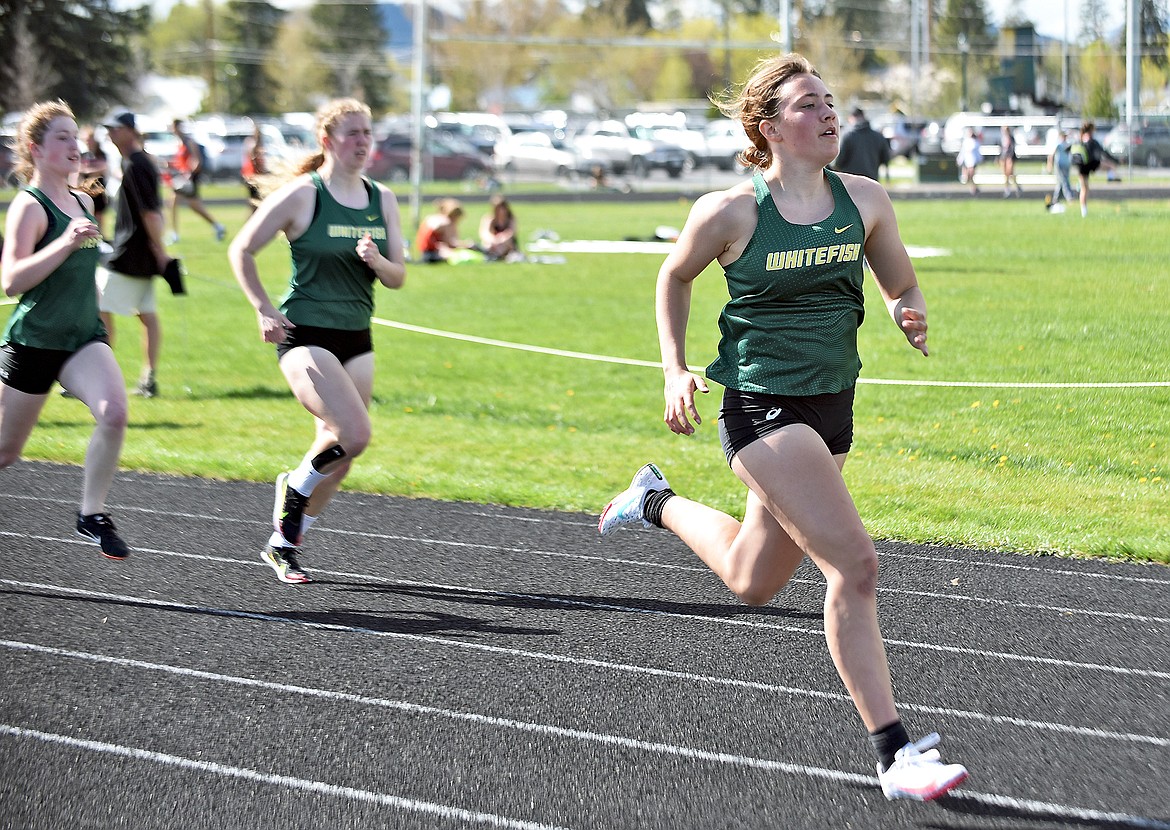 Whitefish's Mady Alexander leads teammates Lauren Ramsey and Hanna Gawe in the 400 meter race at the Whitefish-Flathead track dual on Thursday at WHS. (Whitney England/Whitefish Pilot)