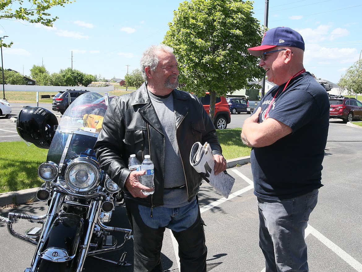 Thomas Bird, left, chats with Post Falls American Legion adjutant Tim Shaw during a visit Monday on Bird's 16,000-mile cross-country motorcycle ride to pay off American Legion mortgage debt.