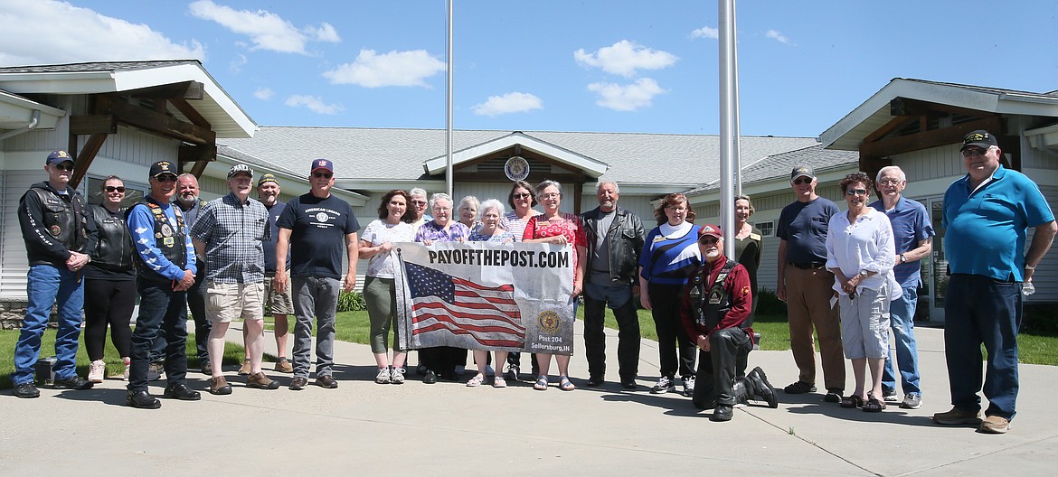 A friendly crew poses with Thomas Bird (center right, in the leather jacket) at the Post Falls American Legion on Monday. Bird is visiting at least one post per state in efforts to pay off mortgages for posts across the country.