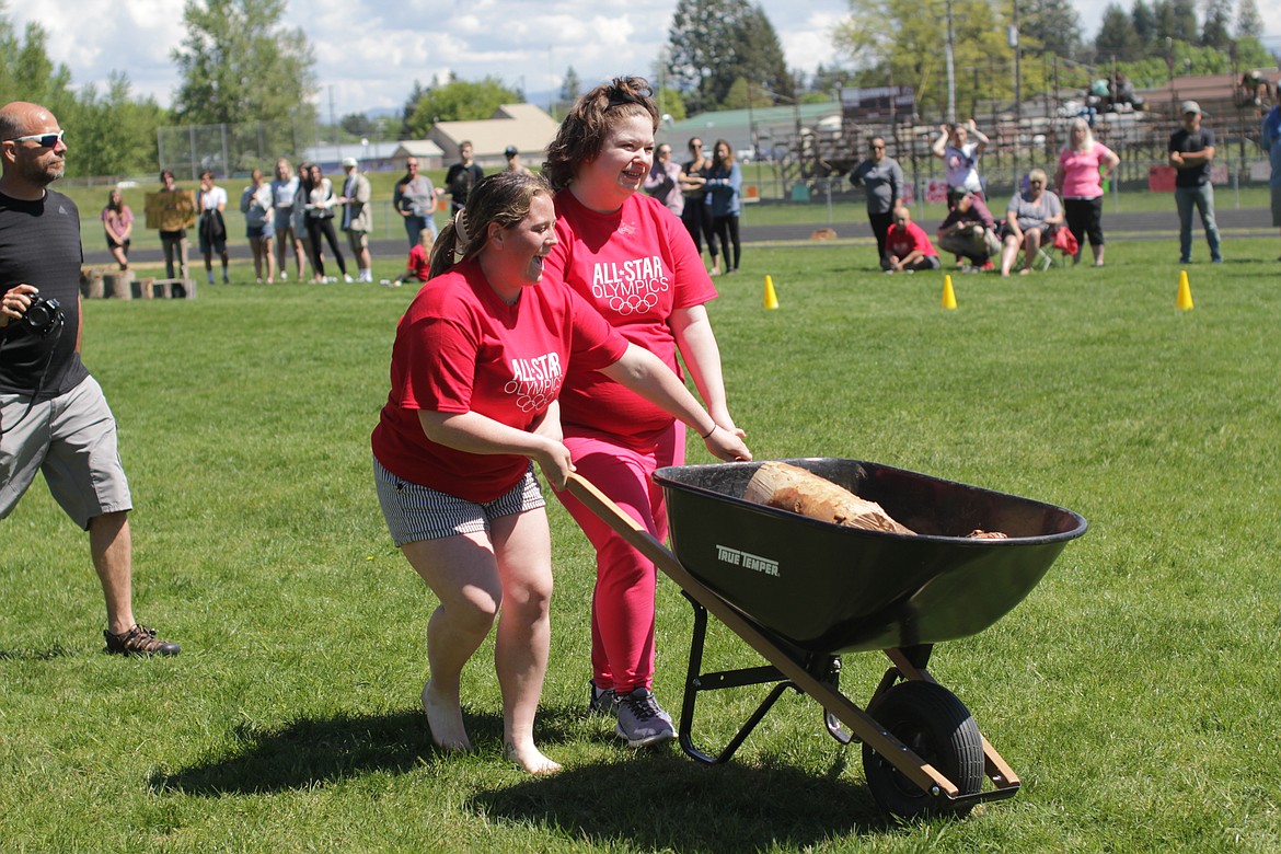 Breanna Stevens pushes a wheelbarrow through the All Star Olympics obstacle course.