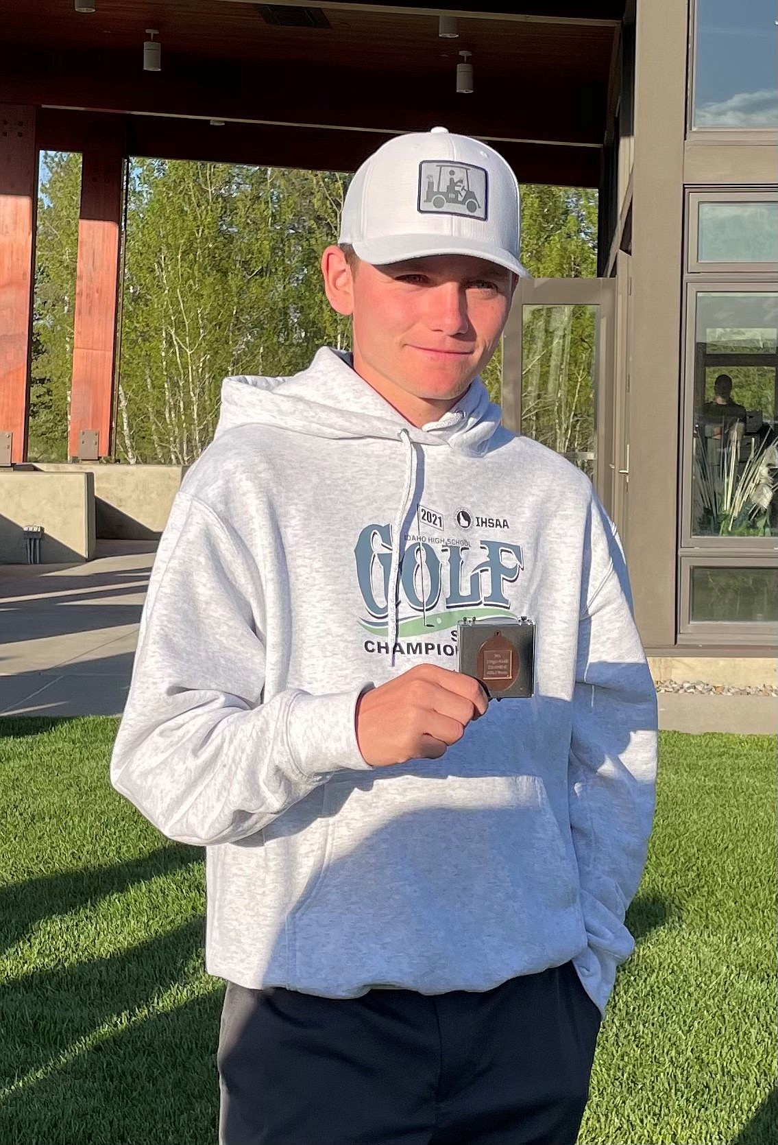 Clark Fork's Cole Reuter holds up his medal after placing eighth at the 2A state golf tournament on Tuesday.