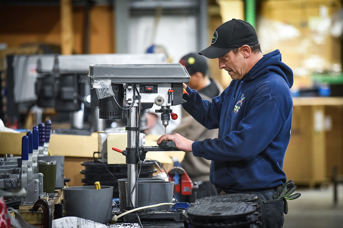 Jason Boudreaux works on repositioning the locking mechanism on injection molded water meter lids at Northern Plastics on Wednesday, May 19. (Casey Kreider/Daily Inter Lake)