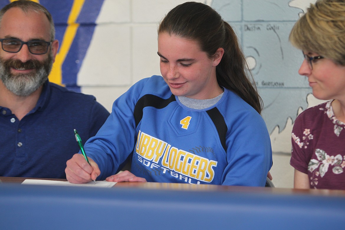 Bethany Thomas signs her letter of intent to play softball for Concordia University on May 19. Her parents Steven and Lisa Thomas look on. (Will Langhorne/The Western News)