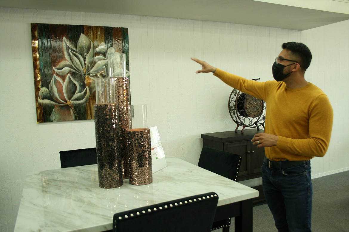 La Imperial Furniture owner Carlos Hernandez, of Moses Lake, demonstrates using colors as the basis for accessorizing in a dining room setting.