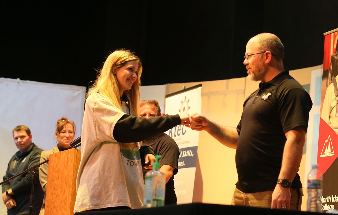 Senior Madison Brunke bumps fists with Mountain View Alternative High School Principal Paul Uzzi on Thursday during a signing ceremony in the school's gym. Seniors signed on to enroll in North Idaho College's Job Corps program while Kootenai Technical Education Campus celebrated a junior and welcomed three sophomores.