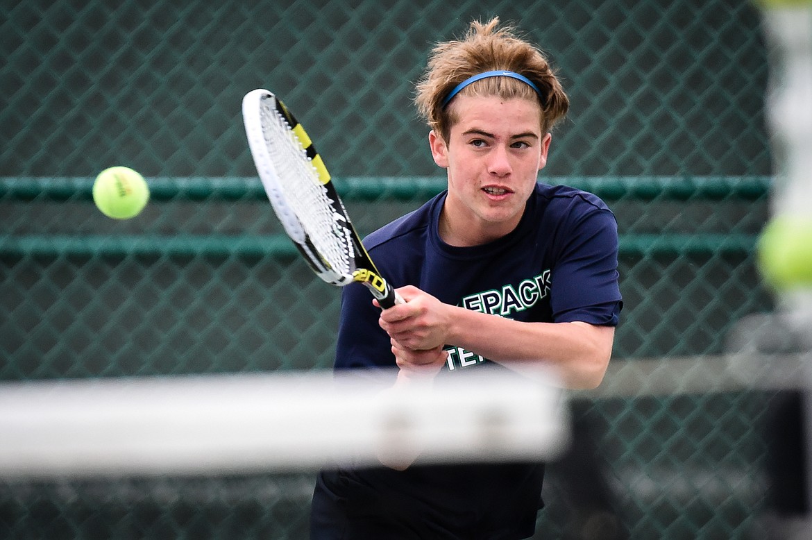 Glacier's Harrison Sanders hits a return in the boys' doubles final with teammate Ethan Purdy against C.M. Russell's Carter Corn and Noah Stimac during the Northern AA Divisional Tennis Tournament at Flathead Valley Community College on Friday. (Casey Kreider/Daily Inter Lake)