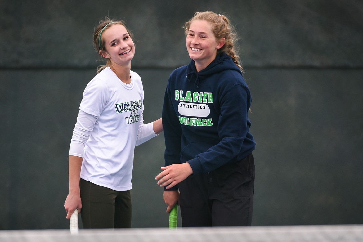 Glacier's Colette Daniels and Haven Speer chat during a break in their doubles match against C.M. Russell's Madison George and Becca Sherman during the Northern AA Divisional Tennis Tournament at Flathead Valley Community College on Friday. (Casey Kreider/Daily Inter Lake)