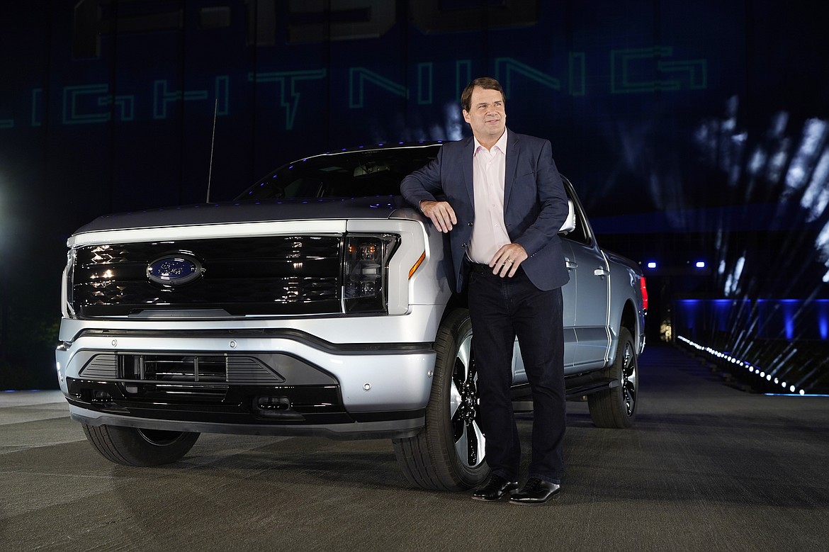 Jim Farley, Ford Motor Company's chief executive officer, stands next to the company's new Ford F-150 Lightning, Wednesday, May 19, 2021, in Dearborn, Mich. On the outside, the electric version of Ford's F-150 pickup looks about the same as the wildly popular gas-powered truck. The new truck called the F-150 Lightning can go up to 300 miles per charge, with a starting price of just under $40,000. (AP Photo/Carlos Osorio)