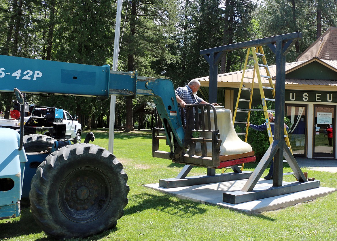 Fred Dehn rides along as the city's historic bell is maneuvered into place.