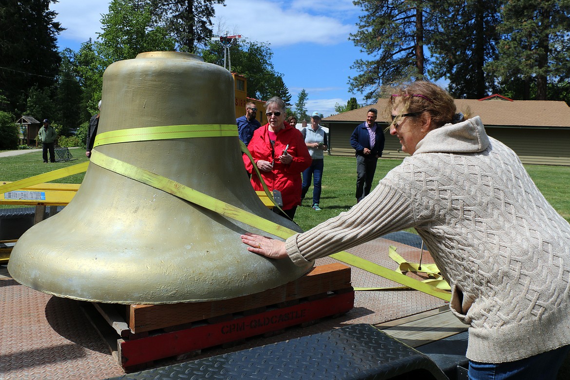 Karin Wedemeyer, director of the Music Conservatory of Sandpoint, gives the city of Sandpoint's historic fire bell a welcome pat home.