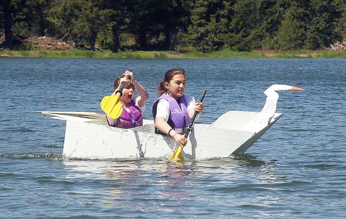 12-year-old Jenna Olson (left, er, stern) and 11-year-old Adaira Tyler (right — I mean, bow) head for shore in the Spirit Lake Area Chamber of Commerce's inaugural Cardboard Boat Regatta Saturday. (CRAIG NORTHRUP/Press)