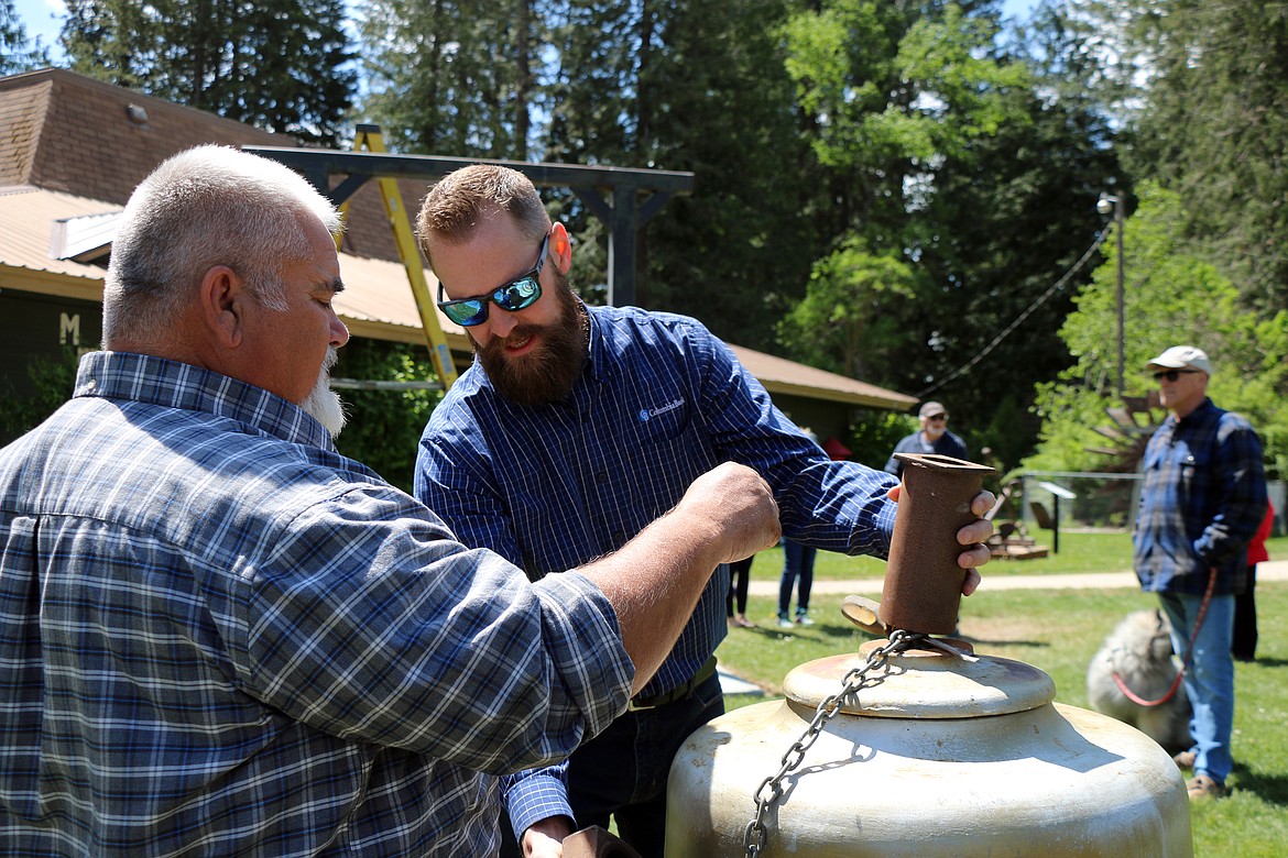 Fred Dehn and Luke Hedquist get the bell ready to hoist into place.