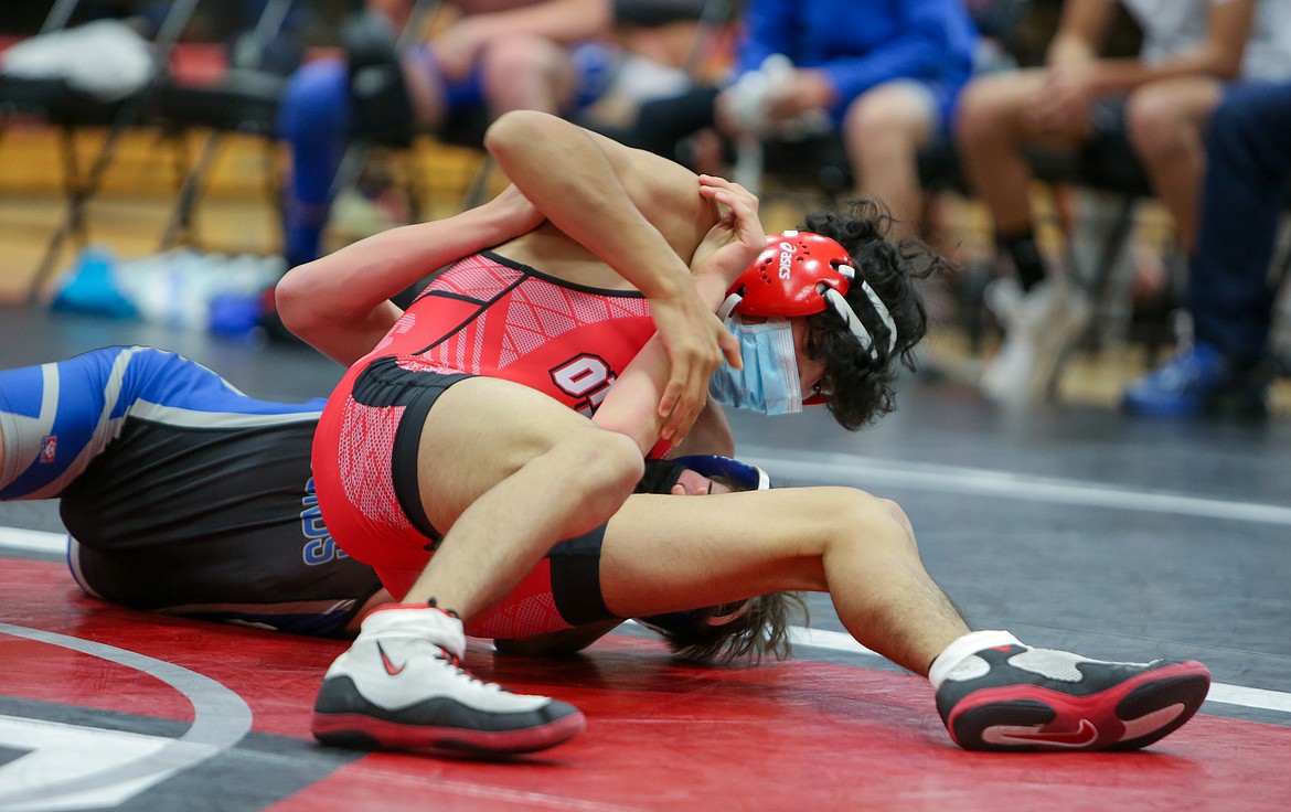 Othello High School’s Adriel Flores fights to pin his opponent in his win over Pullman’s Mason Townsend in the 126 weight class last Thursday in Othello.