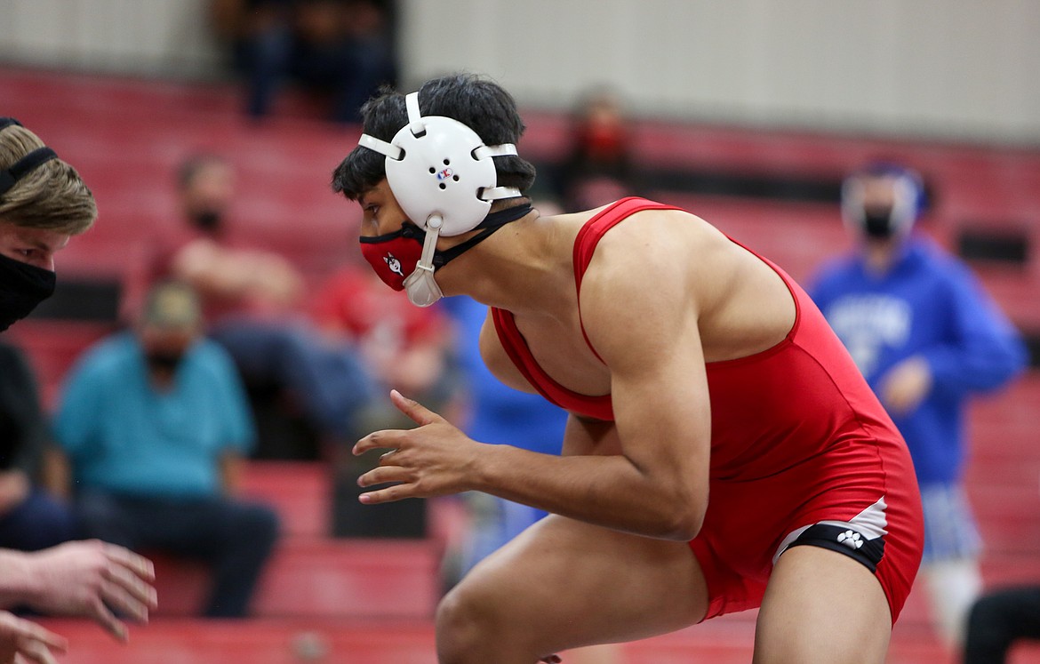 Othello High School’s Arturo Solorio matches up with his opponent on the mat in their bout at the 170-pound weight class last Thursday evening in Othello.