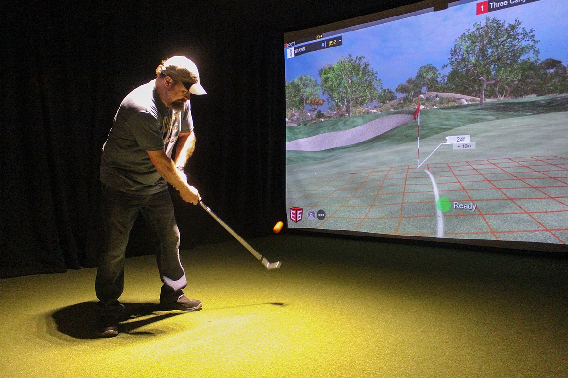 Travis Laibl chips his shot up onto the virtual green at the Moses Lake Divots Indoor Golf facility on April 30, while out enjoying his birthday.