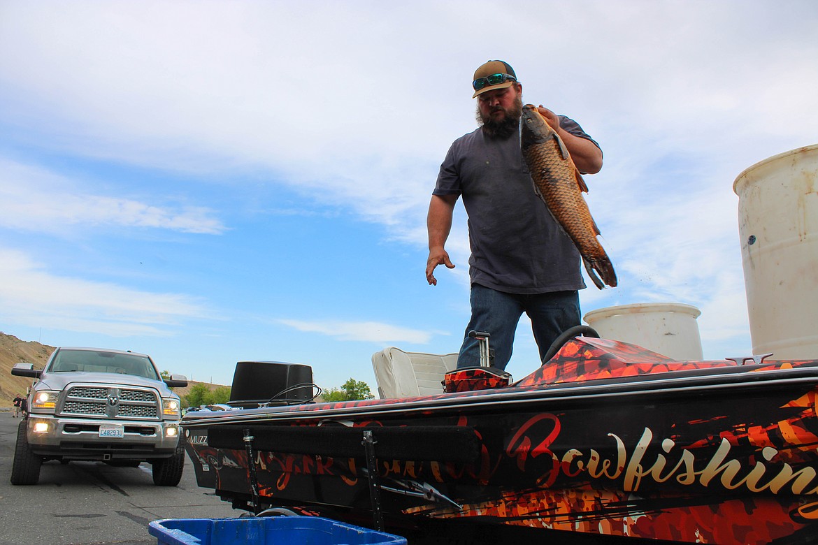Bryan Vandlen loads carp into barrels to be used as crawdad bait at Saturday’s Carp Classic Tournament in Moses Lake.