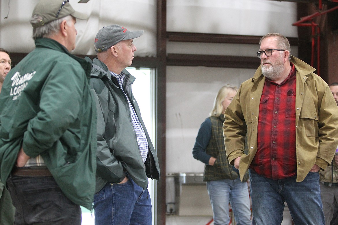 Lincoln County Commissioner Mark Peck (D-1) speaks with Gov. Greg Gianforte about plans to build a wood processing plant near Libby on May 21. (Will Langhorne/The Western News)
