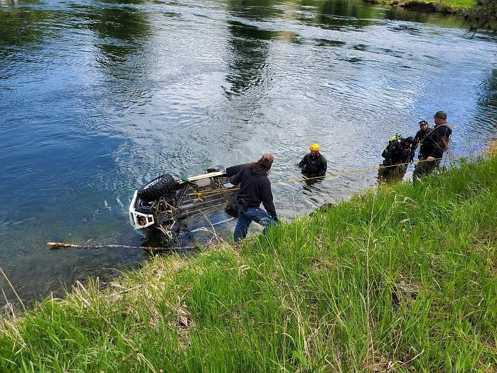 Emergency personnel work to pull up the submerged UTV out from the St. Joe River on Saturday.