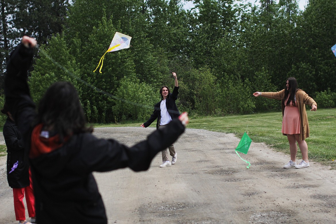 Left to right: Baxter Pollard Eoin Eddy and  Mirabella Nizzoli fly kites Friday.