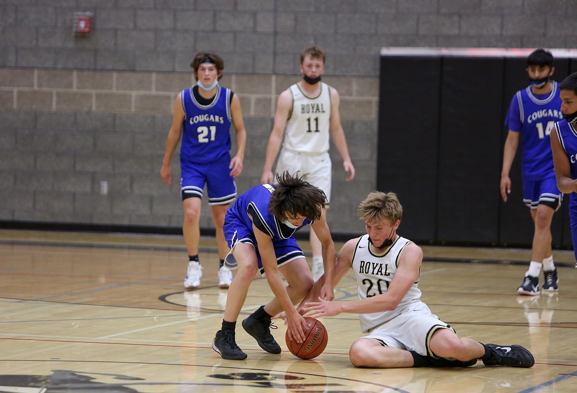 Warden High School's Owen Cox and Royal High School's Caleb Christensen fight for a loose ball before Cox came away with the turnover on Monday night at Royal Intermediate School.