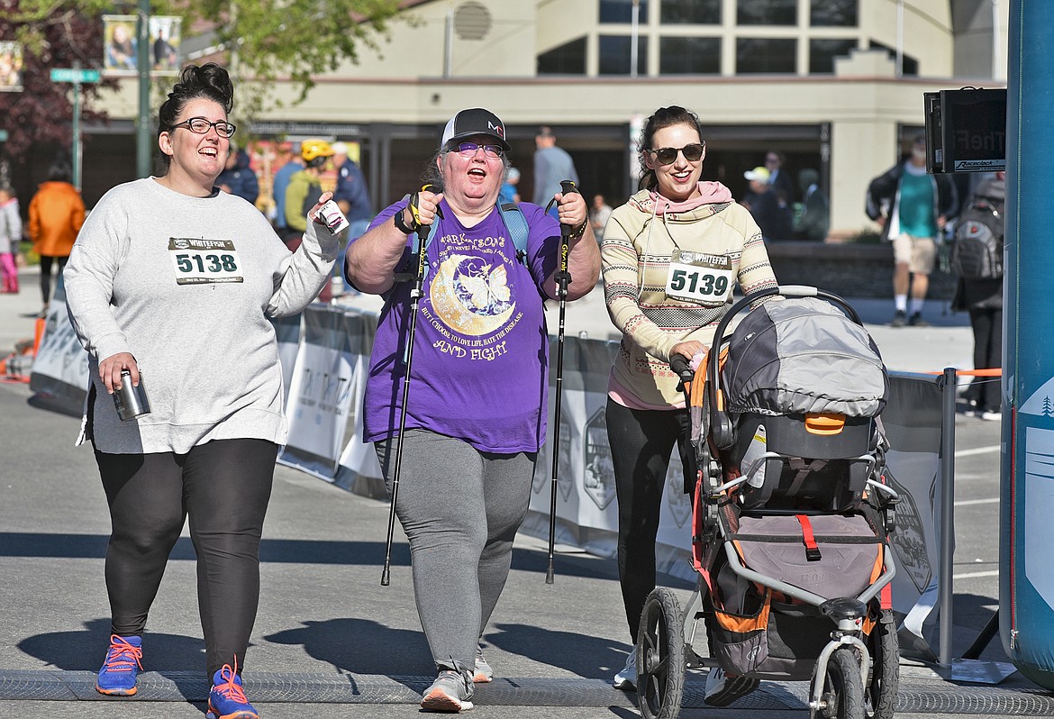 Kristi Seymour of Chinook, Montana, and Avery and Samantha Holshue of Canyon Creek, Montana, cross the finish line in the 5k event during the Whitefish Marathon on Saturday. (Whitney England/Whitefish Pilot)