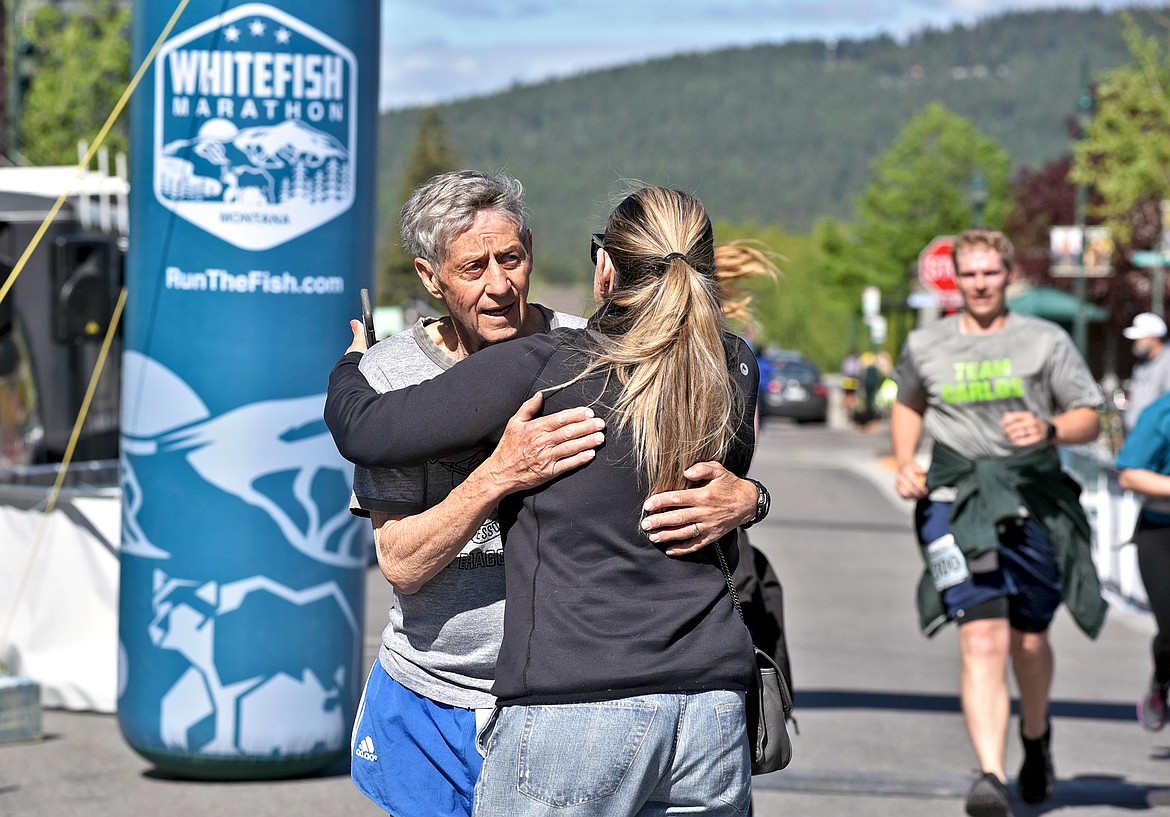 A spectator congratulates William Anderson of Columbia Falls as he crosses the finish line of the Whitefish half marathon on Saturday. (Whitney England/Whitefish Pilot)