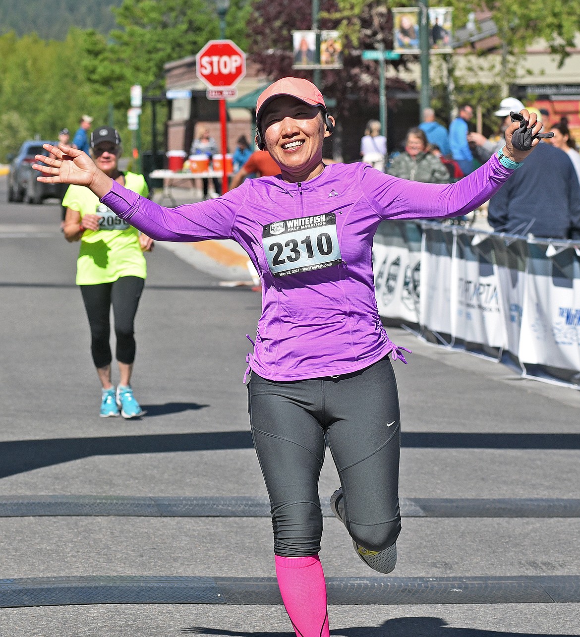 Hyojin Meadows of Spokane, Washington celebrates as she runs through the finish line of the Whitefish half marathon event on Saturday. (Whitney England/Whitefish Pilot)