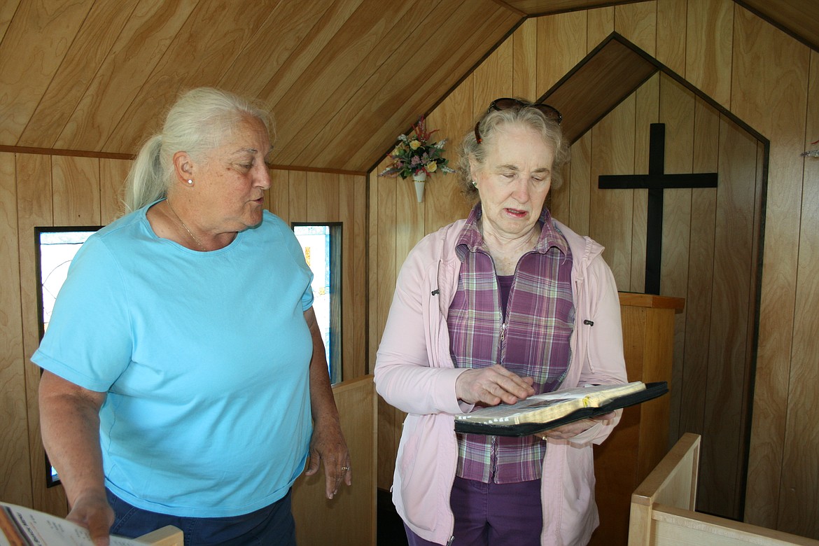 Carolyn Holmes (left) and Jan Hansen (right) look over the Spanish-language Bible found in the chapel at Desert Aire. Volunteers refurbished the chapel in 2020.