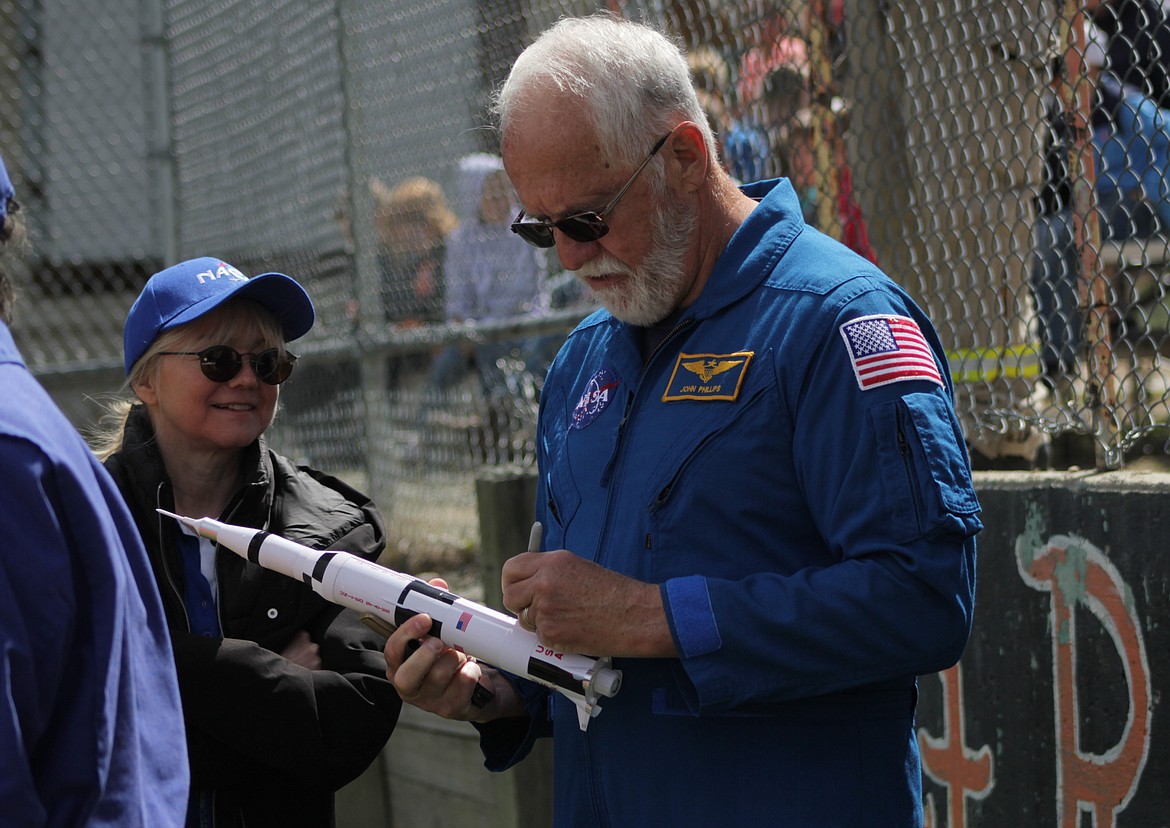 Retired astronaut John Phillips signs a rocket Friday at Priest River Elementary.