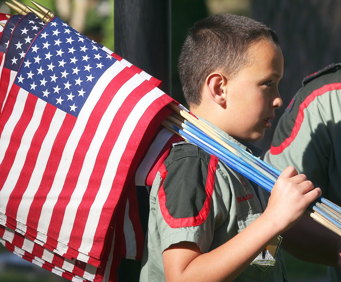 William Gant holds flags at Forest Cemetery Wednesday.