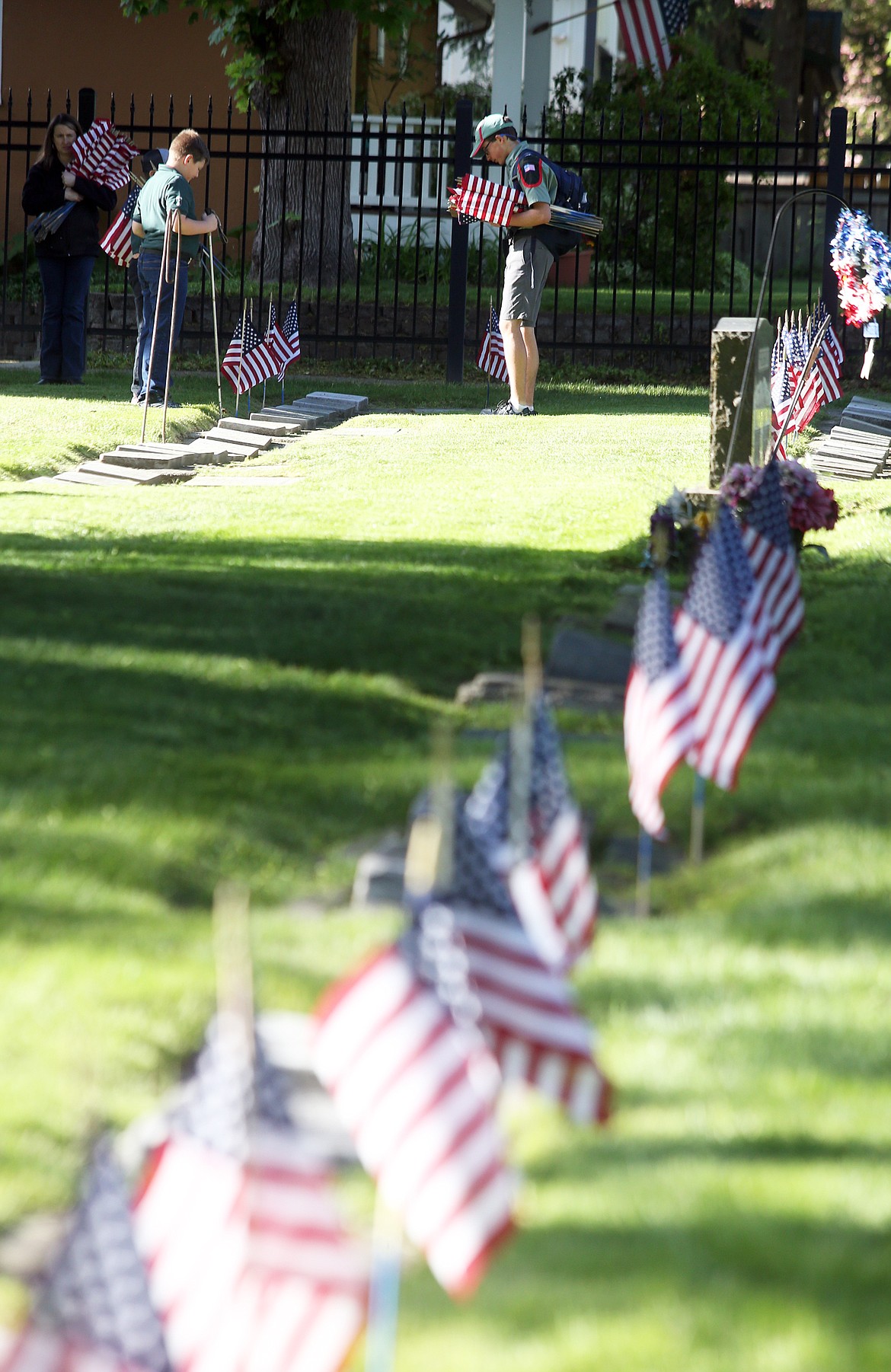 Trail Life USA youth plant flags at Forest Cemetery Wednesday.