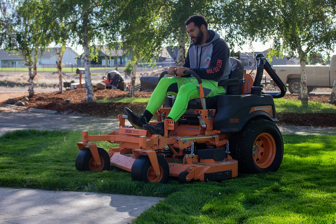 Domanique Benham with EnvyUs Lawn Care trims a lawn in Moses Lake.