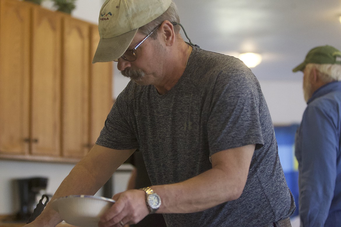 Rick Morrow serves a plate during a veterans suicide awareness meeting at the Troy Community Baptist Church in April. (Will Langhorne/The Western News)