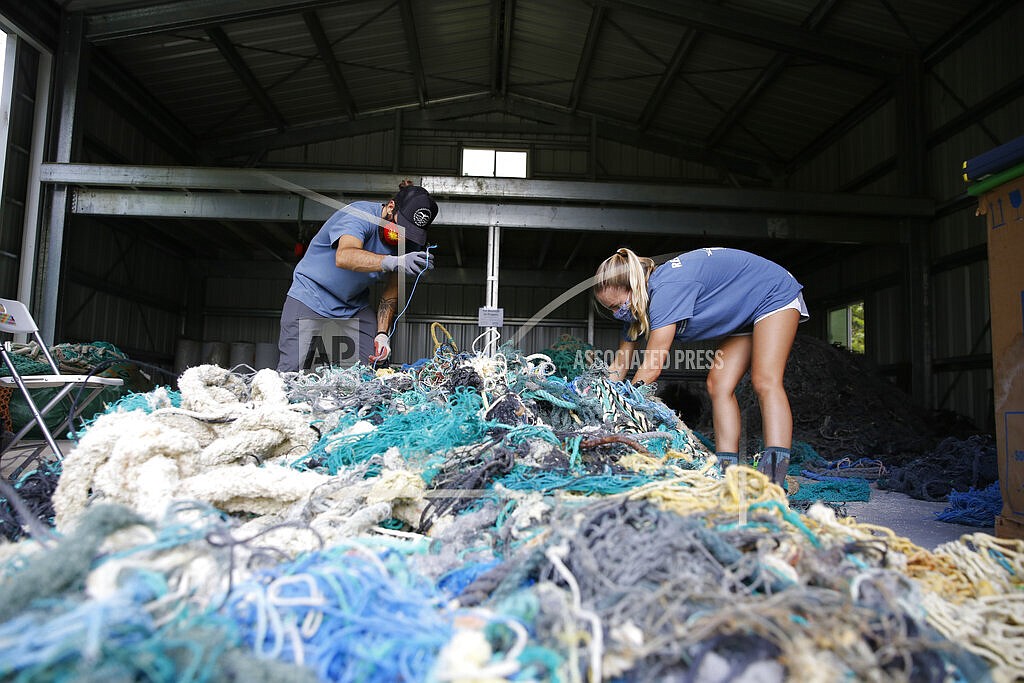 (AP Photo/Caleb Jones)
Hawaii Pacific University graduate student Drew McWhirter, left, and Raquel Corniuk, a research technician at the university's Center for Marine Debris Research, pull apart a massive entanglement of ghost nets on Wednesday, May 12, 2021 in Kaneohe, Hawaii. The two are part of a study that is attempting to trace derelict fishing gear that washes ashore in Hawaii back to the manufacturers and fisheries that it came from.