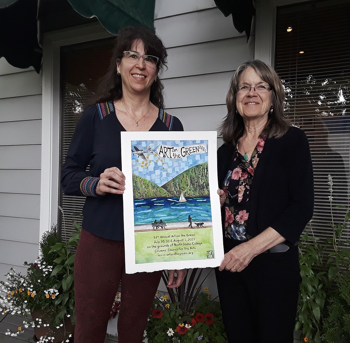Artist Karin Austin, left, and Citizens' Council for the Arts' treasurer Anne Solomon display the winning entry in the council's annual poster contest. Austin's watercolor will be the face of this year's Art on the Green, which was forced to take a one-year break in 2020 due to the COVID-19 pandemic. (CRAIG NORTHRUP/Press)